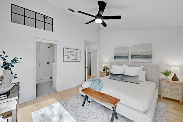 bedroom featuring ensuite bath, ceiling fan, high vaulted ceiling, and light hardwood / wood-style floors