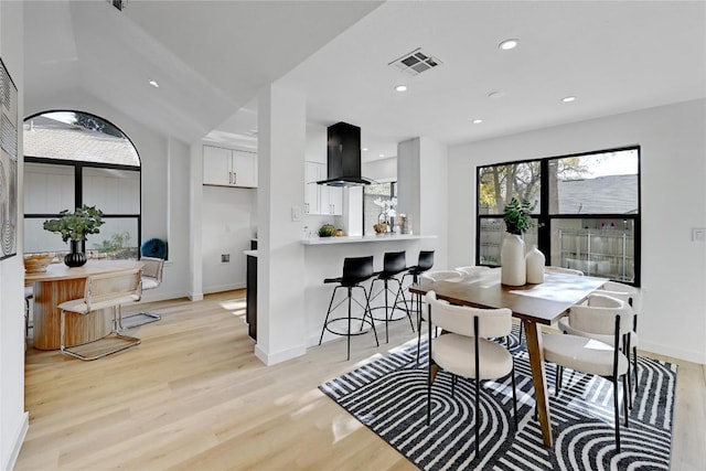 dining area with lofted ceiling and light wood-type flooring