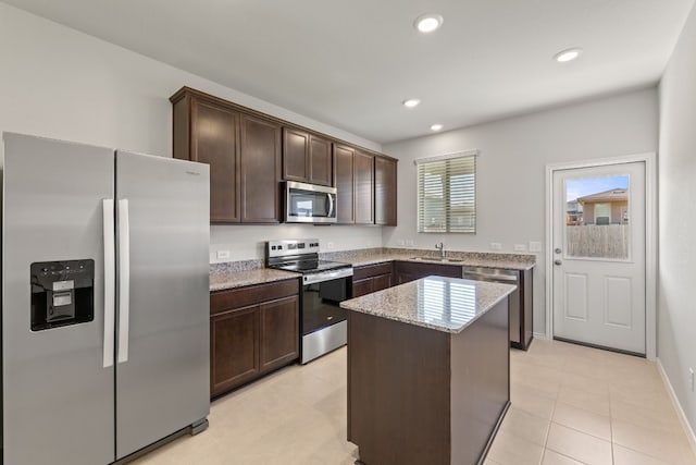 kitchen with a kitchen island, dark brown cabinetry, sink, and appliances with stainless steel finishes