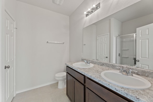 bathroom featuring tile patterned floors, vanity, toilet, and a shower with shower door