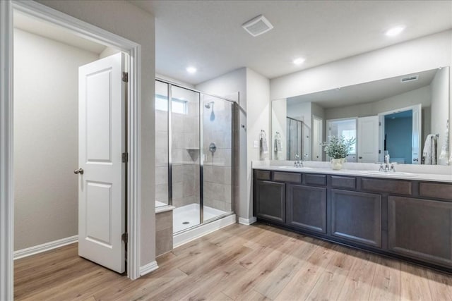 bathroom featuring vanity, wood-type flooring, and walk in shower