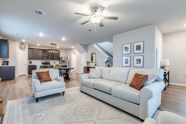 living room with ceiling fan and light hardwood / wood-style floors