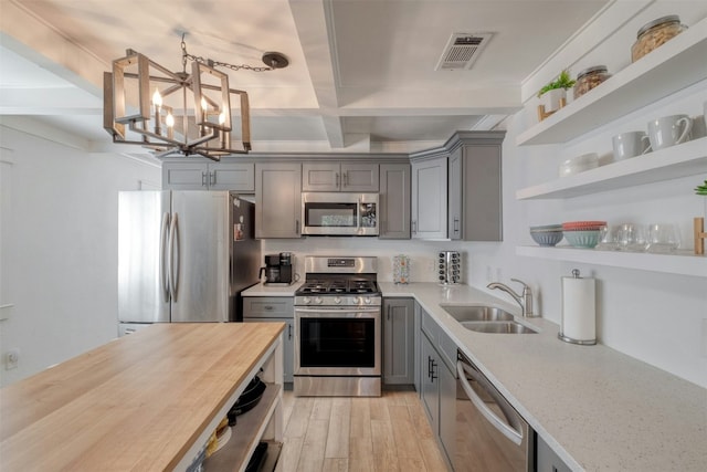 kitchen with beamed ceiling, sink, stainless steel appliances, and wooden counters