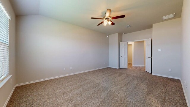 unfurnished bedroom featuring ceiling fan, carpet, and vaulted ceiling