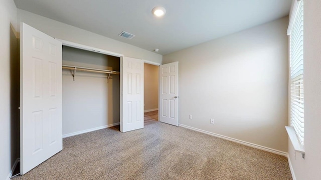 unfurnished bedroom featuring carpet, a closet, and multiple windows