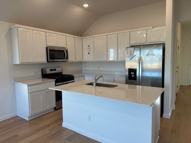223 Spirit St, Elgin, TX 78621 - kitchen with appliances with stainless steel finishes, a sink, vaulted ceiling, wood finished floors, and light countertops