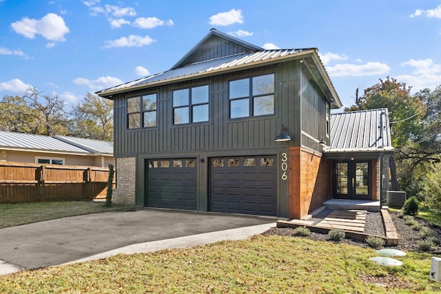 exterior space featuring cooling unit, a garage, and a front lawn