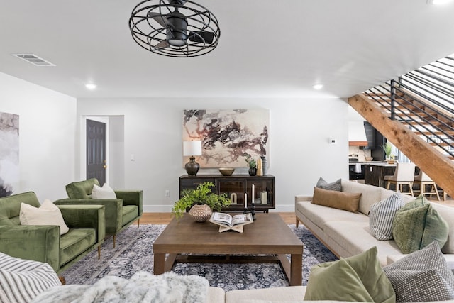 living room featuring wood-type flooring and ceiling fan