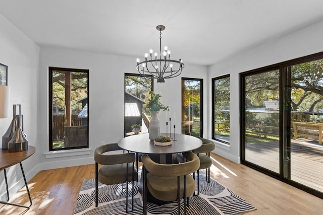 dining area featuring plenty of natural light, light wood-type flooring, and a notable chandelier