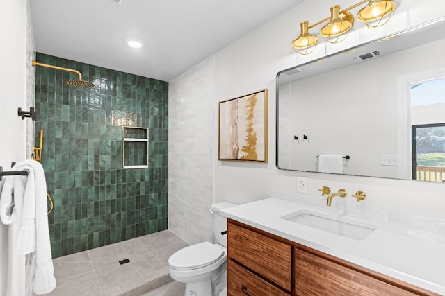 bathroom featuring tile patterned floors, vanity, toilet, and tiled shower