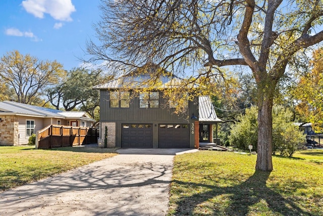 306 Bluebird Cir, Marble Falls, TX 78654 - view of front facade featuring concrete driveway, an attached garage, a front lawn, and a metal roof