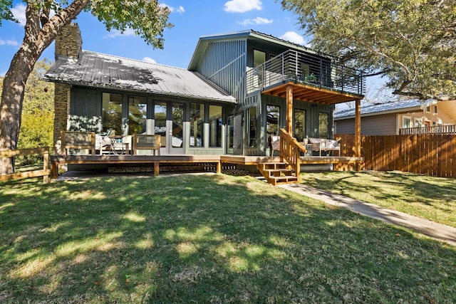 rear view of property with a lawn, a balcony, and french doors