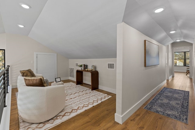 living area featuring wood-type flooring and vaulted ceiling