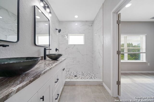 bathroom featuring tiled shower and vanity