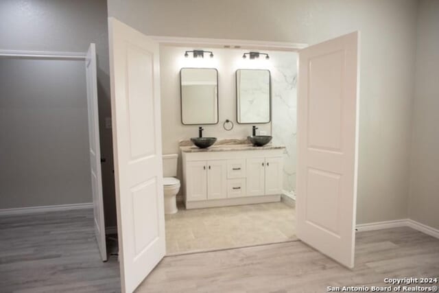 bathroom with hardwood / wood-style floors, vanity, and toilet