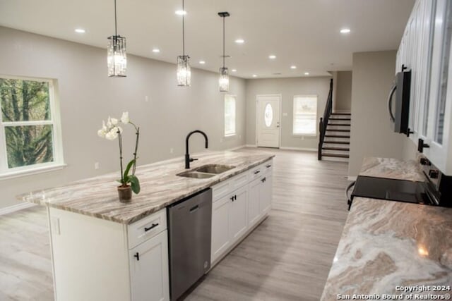 kitchen featuring sink, plenty of natural light, an island with sink, white cabinets, and appliances with stainless steel finishes