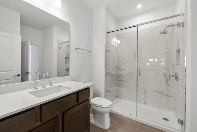 bathroom featuring vanity, wood-type flooring, toilet, and walk in shower