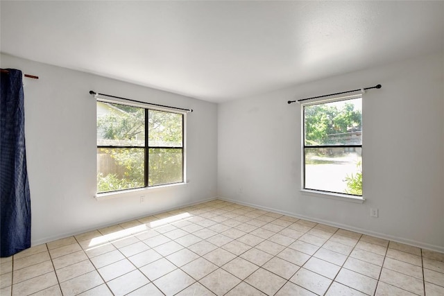 tiled empty room featuring plenty of natural light