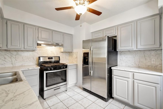 kitchen with appliances with stainless steel finishes, backsplash, gray cabinetry, sink, and light tile patterned floors