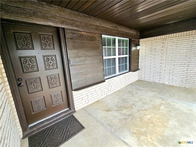 doorway to property with brick siding