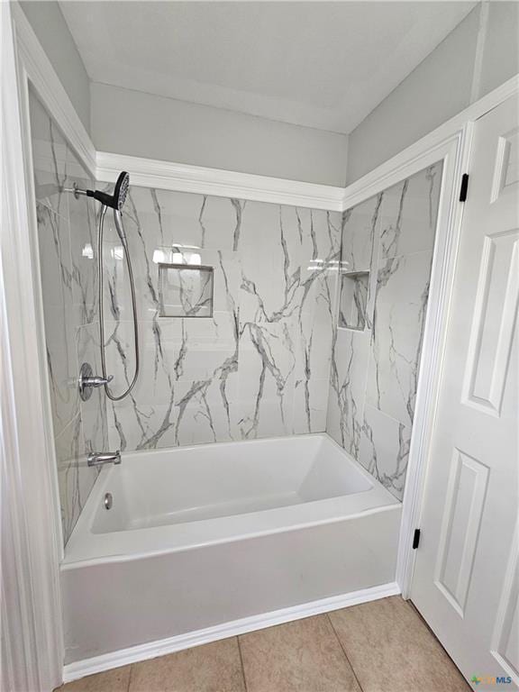 bathroom with tile patterned flooring and washtub / shower combination