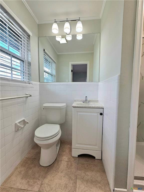 bathroom featuring crown molding, vanity, toilet, tile patterned floors, and tile walls