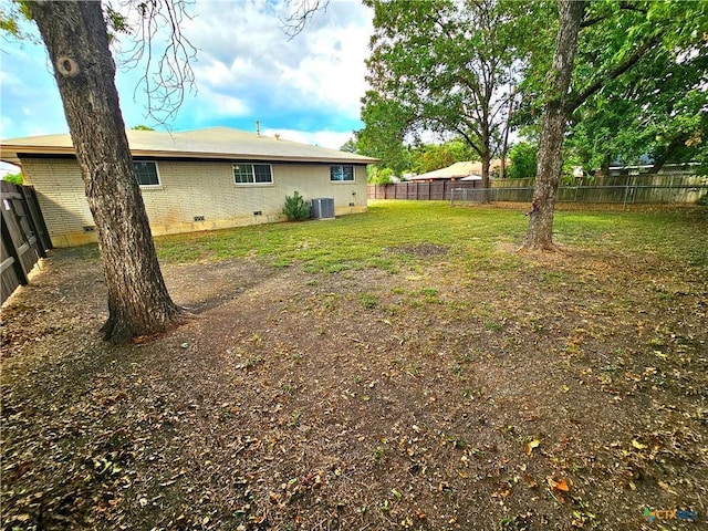 view of yard featuring a fenced backyard and central AC