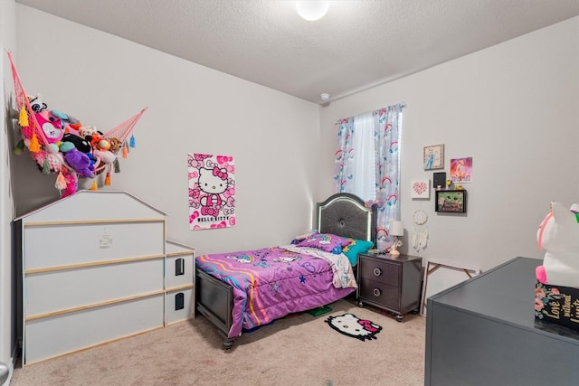 bedroom with light colored carpet and a textured ceiling