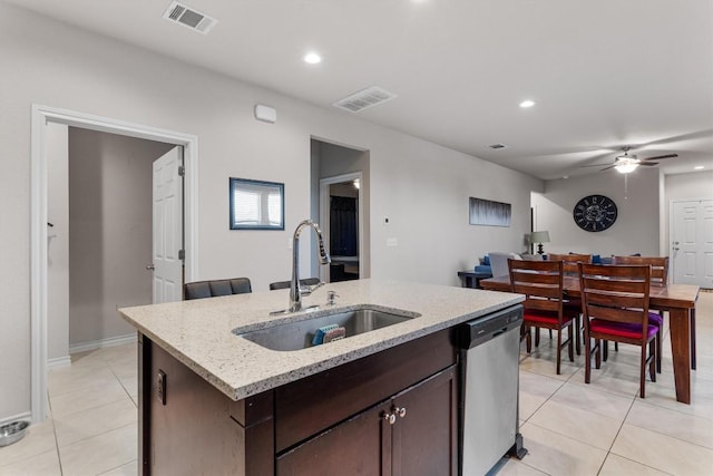 kitchen featuring stainless steel dishwasher, dark brown cabinetry, ceiling fan, sink, and a center island with sink