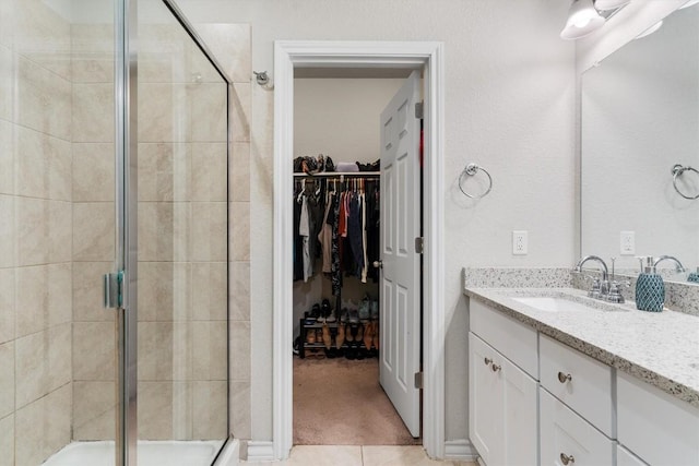 bathroom with tile patterned floors, vanity, and walk in shower