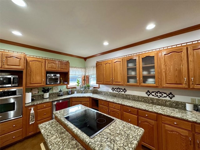 kitchen with light stone countertops, appliances with stainless steel finishes, crown molding, and sink