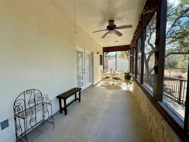 unfurnished sunroom with ceiling fan and french doors