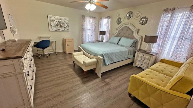 bedroom featuring dark hardwood / wood-style floors, multiple windows, and ceiling fan