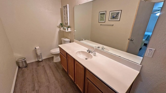 bathroom with hardwood / wood-style floors, vanity, and toilet