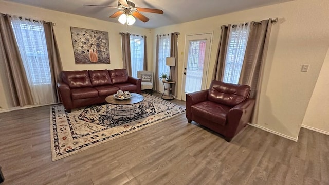 living room featuring ceiling fan and dark hardwood / wood-style flooring