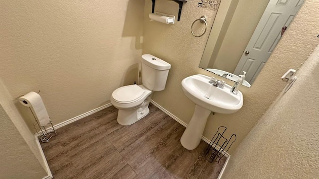 bathroom with wood-type flooring and toilet