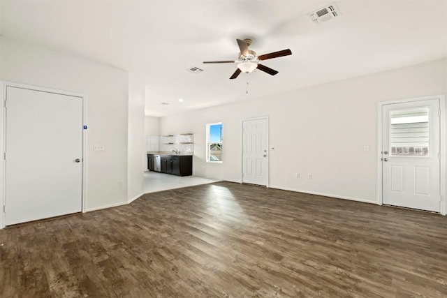 interior space featuring a wealth of natural light, ceiling fan, and dark wood-type flooring