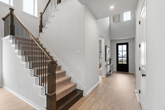 foyer entrance with light hardwood / wood-style flooring and a high ceiling