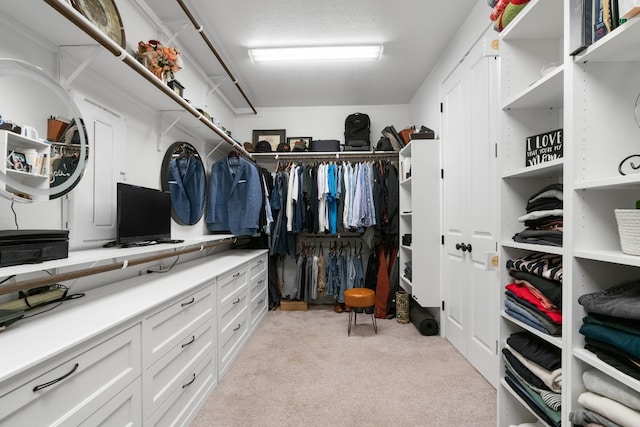 walk in closet with light colored carpet