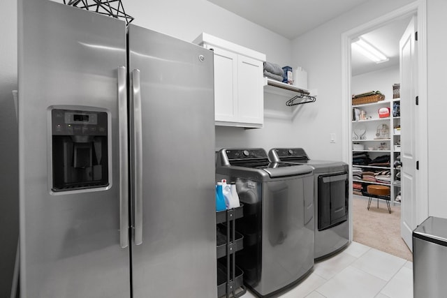 laundry room with washer and clothes dryer, cabinets, and light carpet