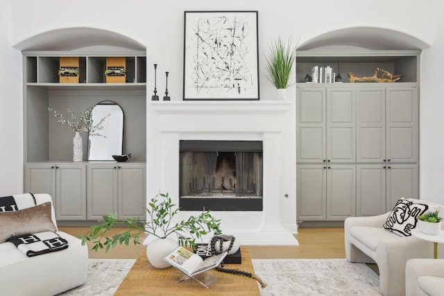 living room with light wood-type flooring and a fireplace with raised hearth