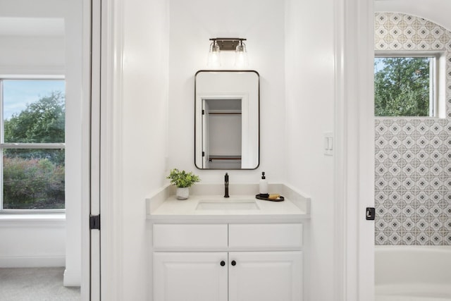 bathroom with shower / bathing tub combination, plenty of natural light, and vanity