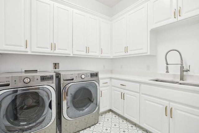 laundry area featuring washing machine and dryer, cabinet space, and a sink