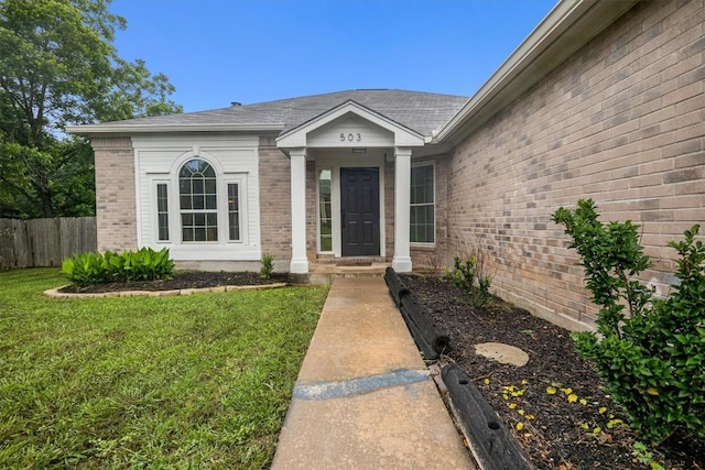 doorway to property with a lawn