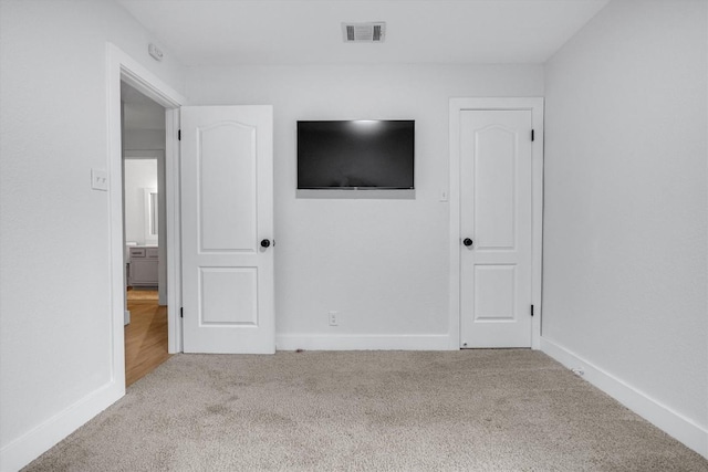 unfurnished bedroom with light colored carpet