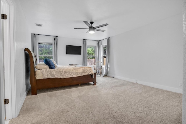 carpeted bedroom featuring ceiling fan and multiple windows