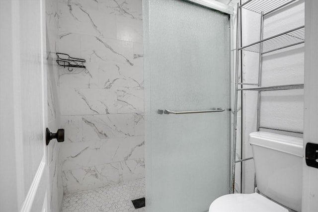 bathroom featuring tiled shower and toilet