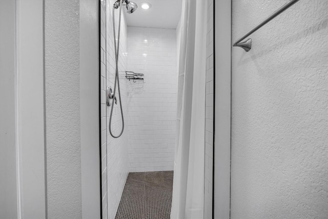 interior details featuring tiled shower