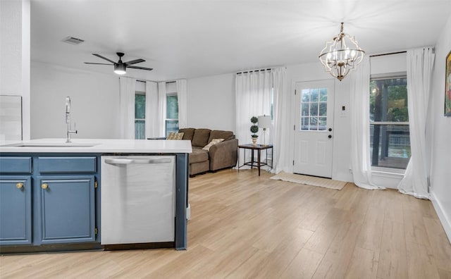 kitchen with ceiling fan with notable chandelier, sink, blue cabinetry, light hardwood / wood-style flooring, and dishwasher