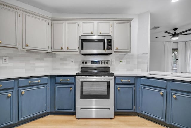 kitchen featuring ceiling fan, sink, blue cabinets, and stainless steel appliances